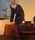 Henry Cockburn as Steve, struggling with some suitcases