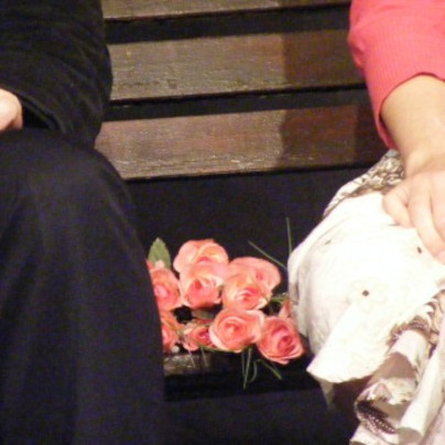 Bunch of flowers between a man and a woman on a bench